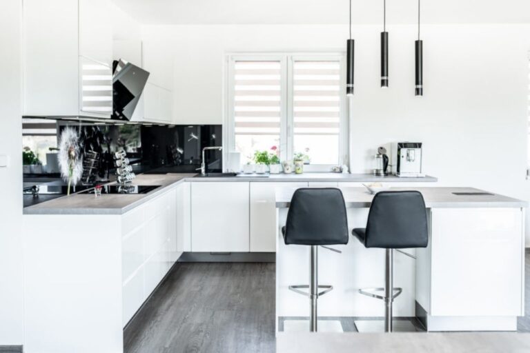 bílá moderní kuchyň s ostrůvkem a barovými židlemi